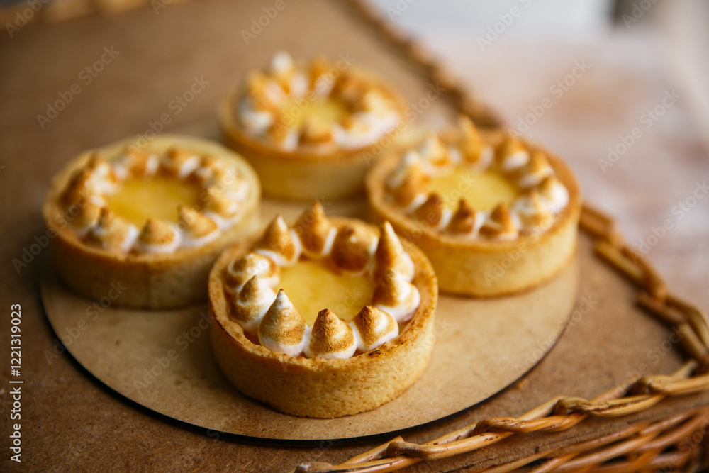 Group delicious Lemon Tartlets on a wood plate, wooden background Group delicious Lemon Tartlets on a wood plate, wooden background