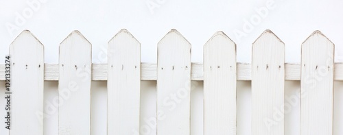 White picket fence against a white wall.