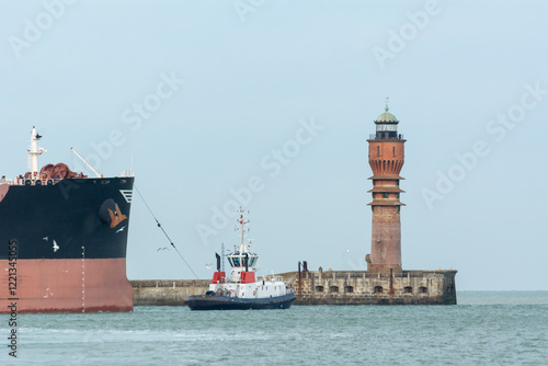 Fotografía Remorqueur tirant un gros bateau devant le feu deSaint Pol dans le port de Dunke