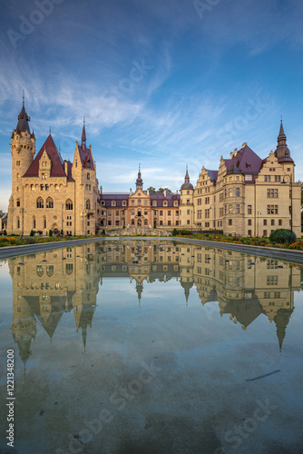 Obraz na płótnie Majestic Moszna Castle on a warm summer morning, surrounded by lush greenery and glowing in soft golden sunlight, reflecting a fairytale-like ambiance perfect for travel and architecture themes. w salonie