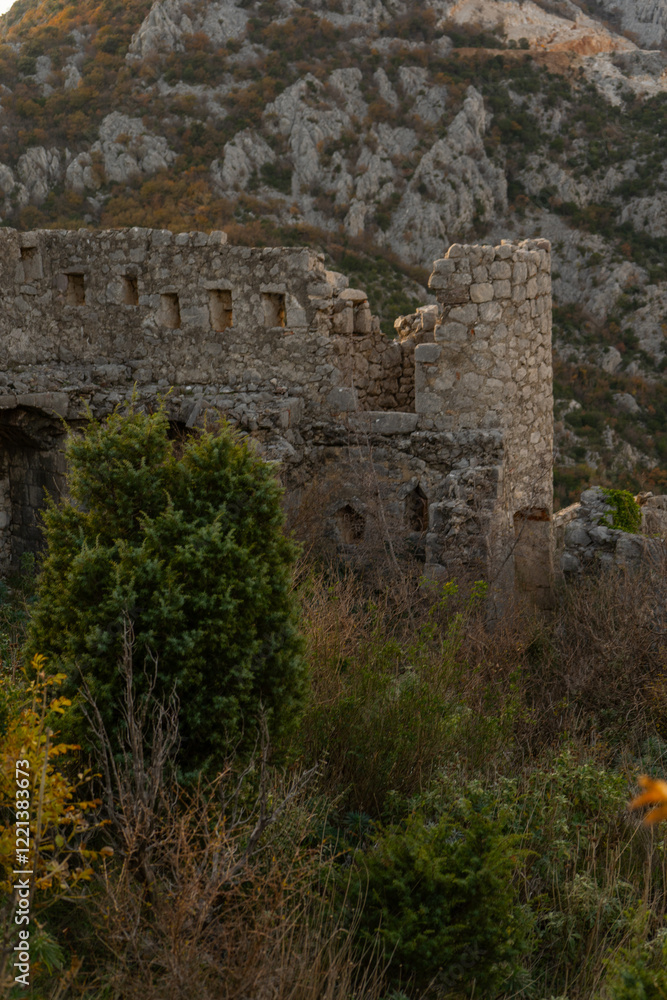 Fototapeta premium Vertical shot of ancient stone arches and medieval walls inside Haj-Nehaj fortress, mysterious ruins on a mountain peak, Montenegro travel aesthetic