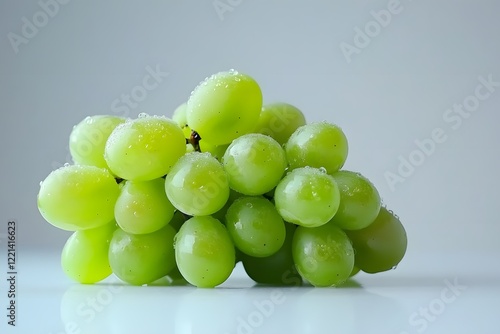 Fresh and juicy green grapes on a white surface. photo