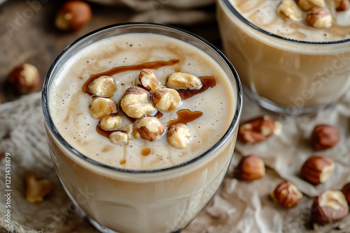 A smooth hazelnut latte with frothy milk, drizzled with hazelnut syrup, and topped with roasted nuts.