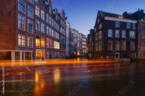 Damrak, Amsterdam, Netherlands. View of houses during sunset. The famous Dutc...