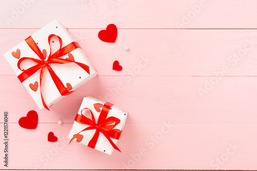 Gift boxes with red hearts on wooden background, top view