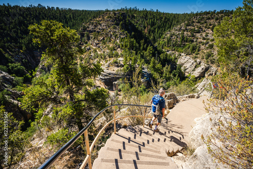 A hiker climbs into the canyon and takes in the view from Island Trail at Walnut Canyon National Monument near Flagstaff, Arizona.