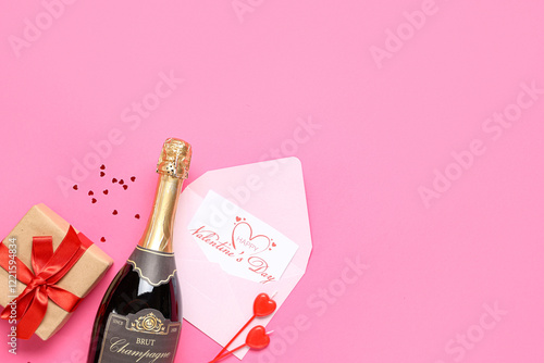Bottle of champagne with gift box, postcard and decor on pink background. Valentine's Day celebration