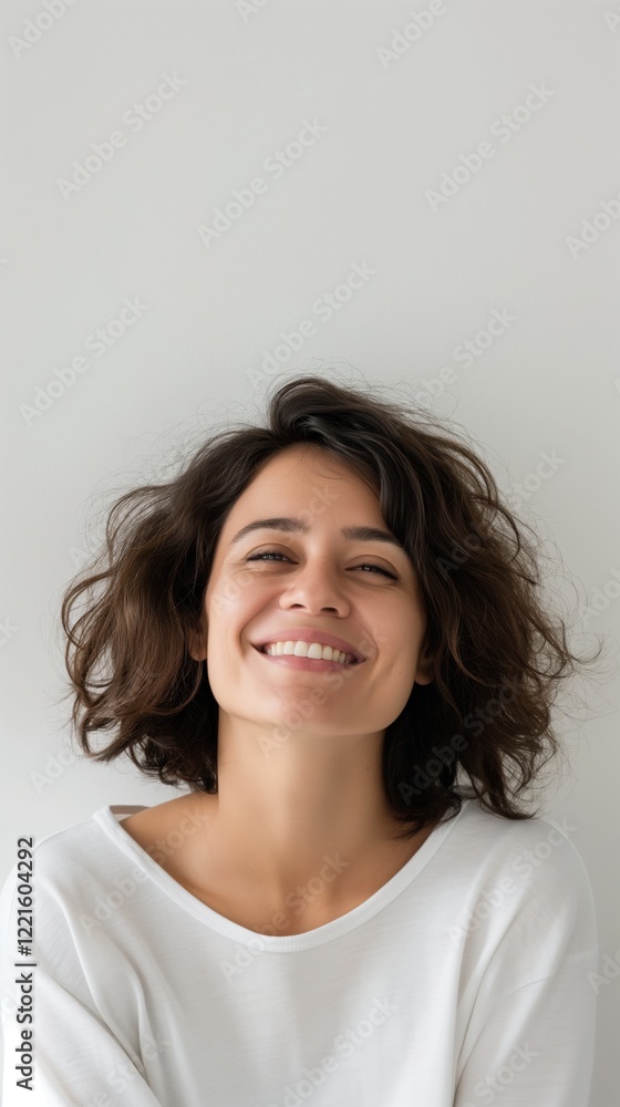 A woman with curly hair smiles broadly while sitting in a cozy setting. Her joyous expression conveys a sense of positivity and contentment in the moment A woman with curly hair smiles broadly while sitting in a cozy setting. Her joyous expression conveys a sense of positivity and contentment in the moment