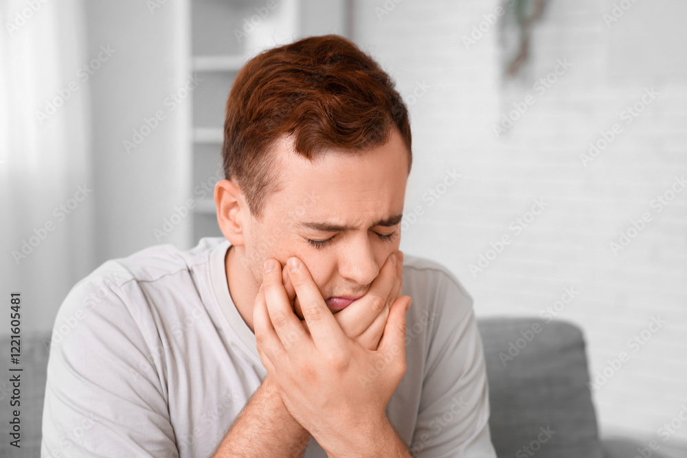 Young man suffering from toothache in room Young man suffering from toothache in room