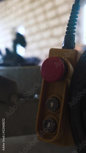 Winch red buttom remote controller in workroom workshop near truck and boat. 4k UHD. Vertical Shot.