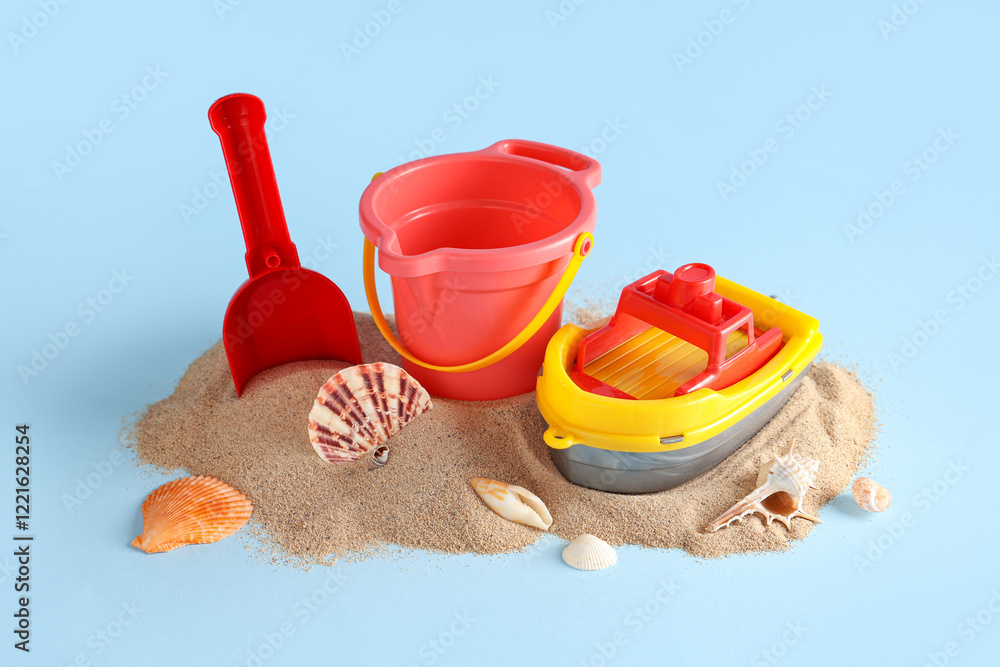 Beach toys and sand on light blue background Beach toys and sand on light blue background
