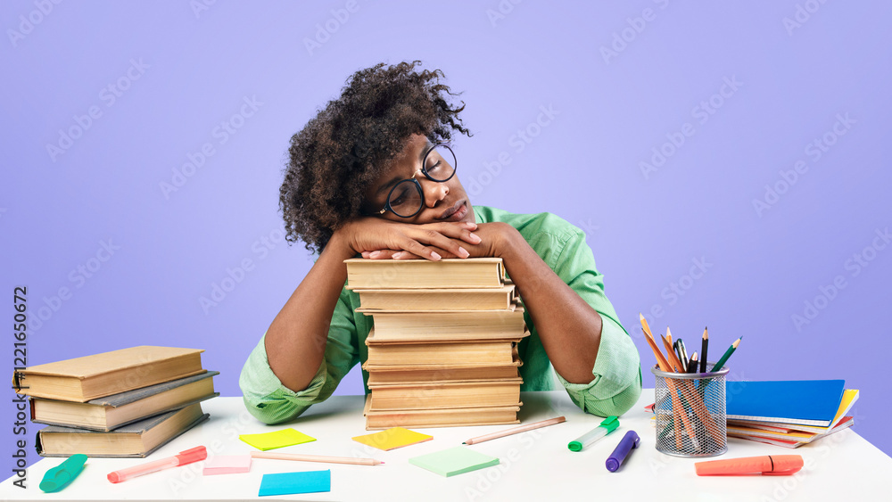 Exhausted black male student sleeping on desk on stacks of books, being tired while preparing for exam on blue studio background. African american teenager feeling overworked while studying Exhausted black male student sleeping on desk on stacks of books, being tired while preparing for exam on blue studio background. African american teenager feeling overworked while studying