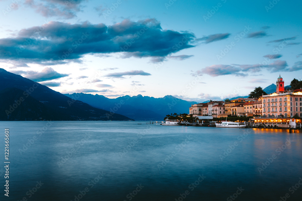 Naklejka premium Lake Como reflecting the charming village of Bellagio, with a dramatic sky filled with vibrant colors at sunset, creating a breathtaking scene in Lombardy, Italy