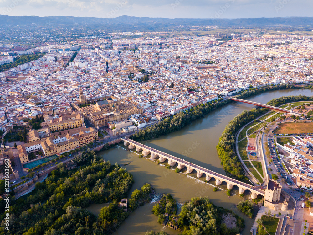 Fototapeta premium Aerial view of Historic centre of Cordoba with antique Roman Bridge over Guadalquivir river and medieval Mosque-Cathedral, Spain