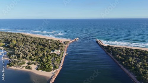 Aerial drone view of Lakes Entrance, Victoria, Australia. Ocean inlet where Cunninghame Arm meets the open sea.  a picturesque coastal destination with sandy beaches, and a well-main breakwater photo