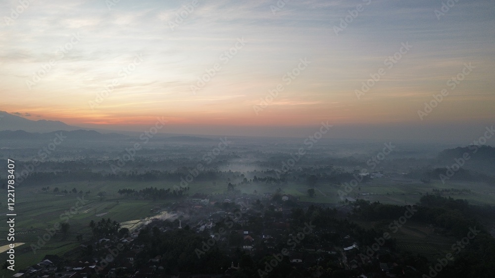 Drone view of rice fields and countryside with mountains background and sunrise and clouds in the morning Drone view of rice fields and countryside with mountains background and sunrise and clouds in the morning