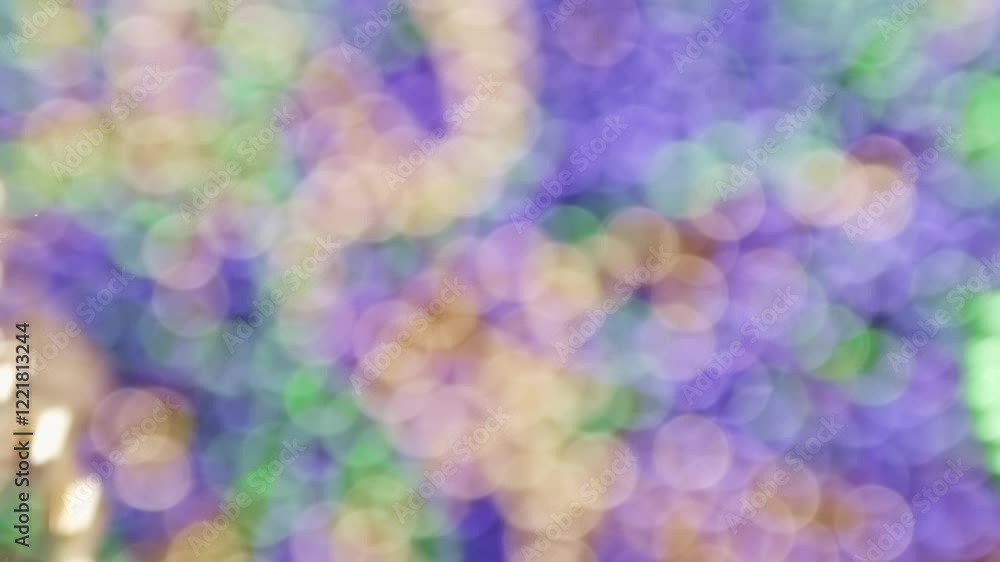 Bokeh of Mardi Gras beads in yellow or gold green and purple. Slow motion throwing of Mardi Gra bead necklaces. Celebrating Mardi Gras, aka Fat Tuesday, with the tradition of throwing beads. Bokeh of Mardi Gras beads in yellow or gold green and purple. Slow motion throwing of Mardi Gra bead necklaces. Celebrating Mardi Gras, aka Fat Tuesday, with the tradition of throwing beads.