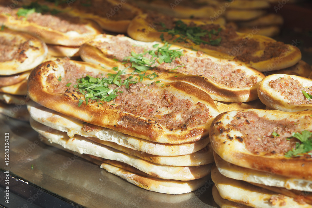 Delicious flatbreads topped with seasoned minced meat and fresh herbs at a street food vendor Delicious flatbreads topped with seasoned minced meat and fresh herbs at a street food vendor