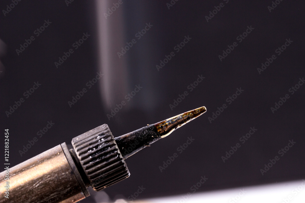 Naklejka premium soldering iron tip in working with smoke