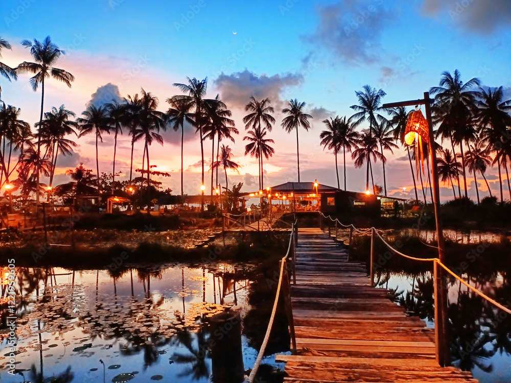 Fototapeta premium Sunset sea beach, palm trees reflection on water, evening ocean landscape, paradise tropical island resort, night bar, lake restaurant, waterfront hotel, romantic dinner, summer holiday, travel, relax