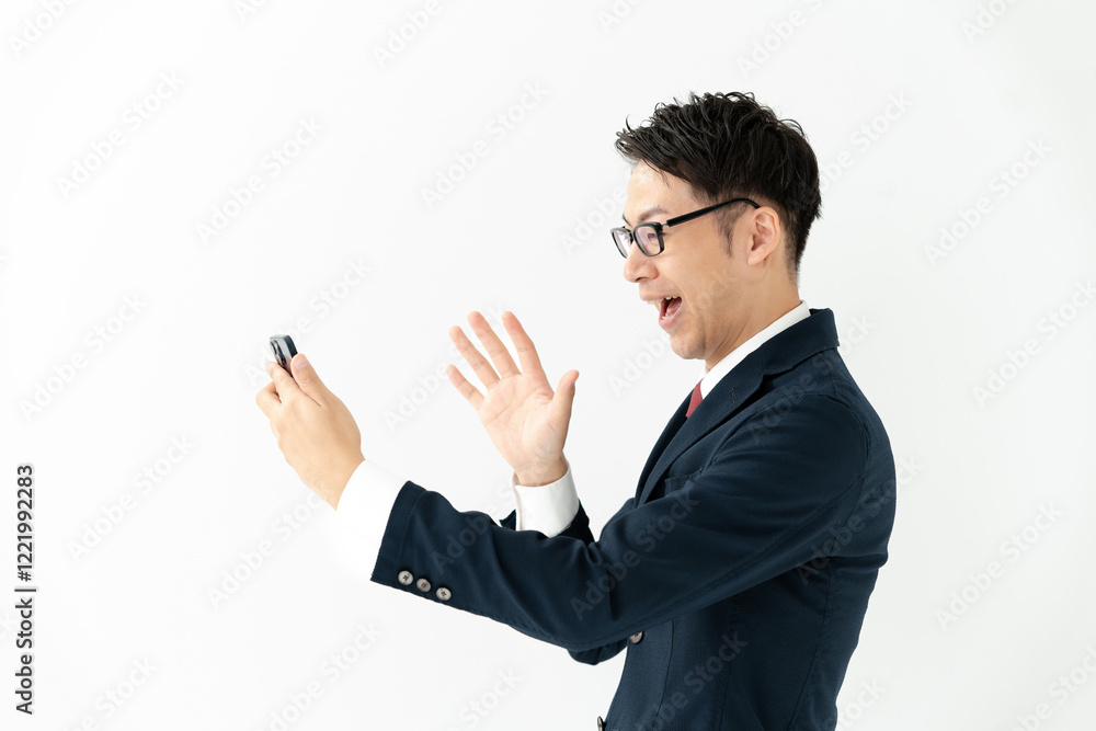 スマホを見て喜ぶビジネスマン スマホを見て喜ぶビジネスマン