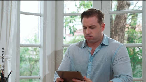 Businessman struggle to solve work problem from home using laptop, sitting on his desk at home office with stressed and frustrated expression, trying to figure out solution for problem. Fastidious