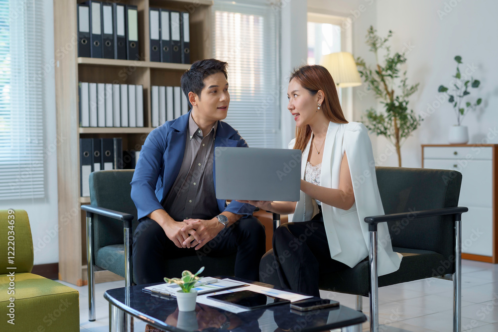 Asian businesspeople discussing using laptop in office Asian businesspeople discussing using laptop in office