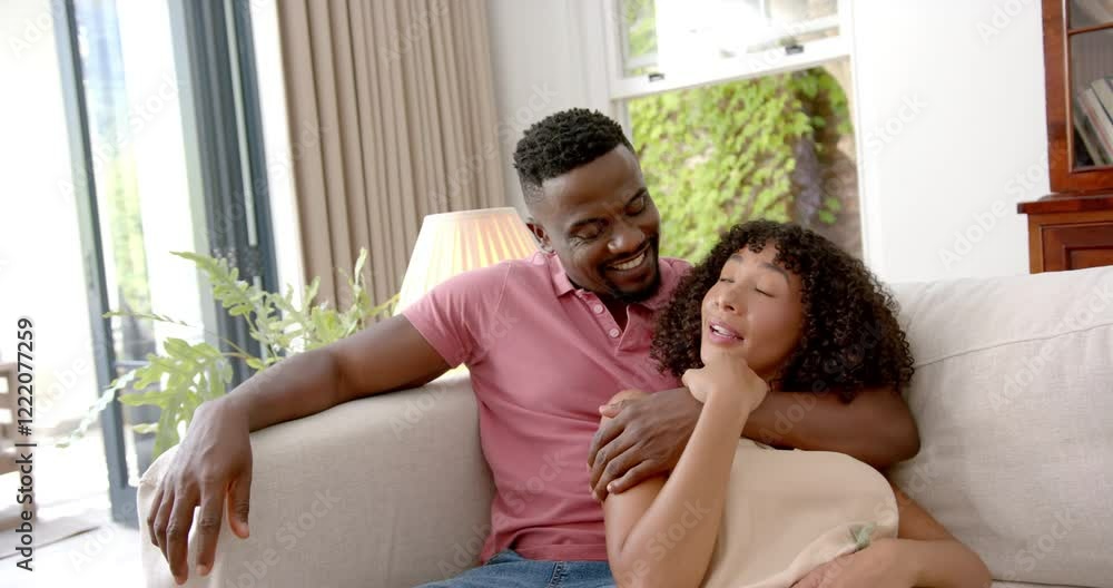 Relaxing on couch, couple smiling and enjoying quality time together at home Relaxing on couch, couple smiling and enjoying quality time together at home
