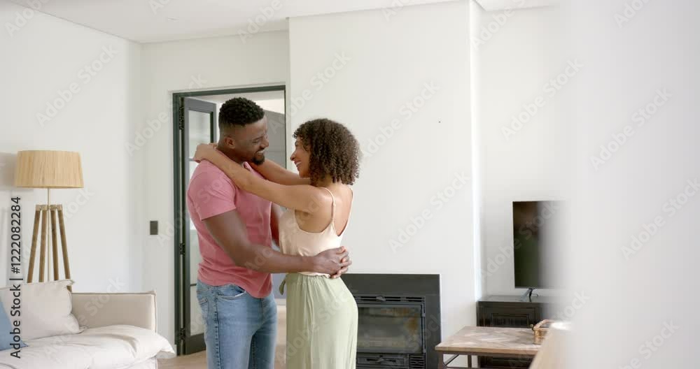 Embracing and smiling, couple enjoying tender moment in living room, copy space Embracing and smiling, couple enjoying tender moment in living room, copy space