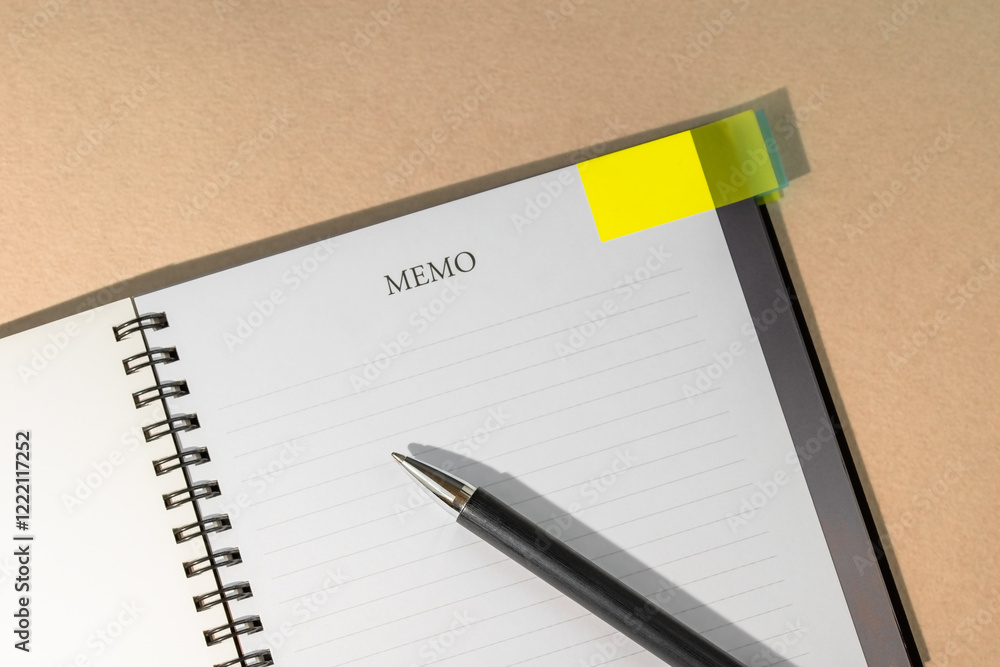 Notebook with yellow page marker note and pen on table. Blank pages for copy space. Reminder concept. Notebook with yellow page marker note and pen on table. Blank pages for copy space. Reminder concept.