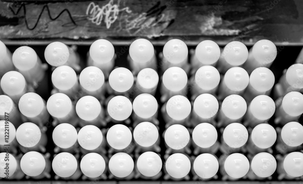 Naklejka premium Rows white pens or pencils in a case on the supermarket showcase. Cosmetics on shelves in supermarket. Pencils in a rows