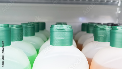 Fotografía Three rows of plastic bottles with green caps on the supermarket window