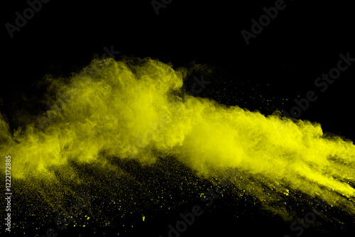 Yellow dust particles explosion on black background.Yellow powder  splash.