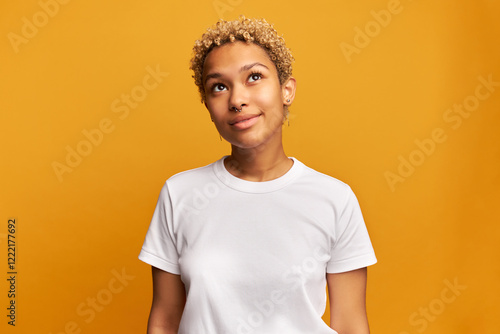 Bilde på lerret Studio image of dreamy smiling dark-skinned blond gen z female in white mockup t