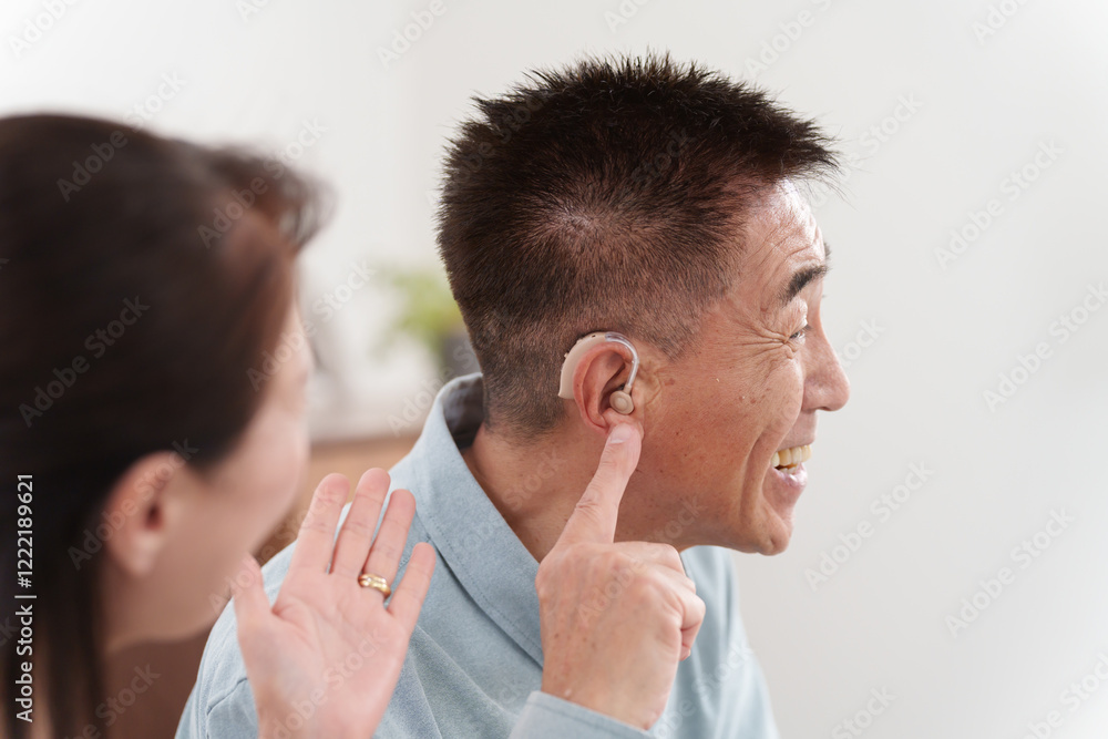 補聴器をつけて会話するシニア男性 補聴器をつけて会話するシニア男性