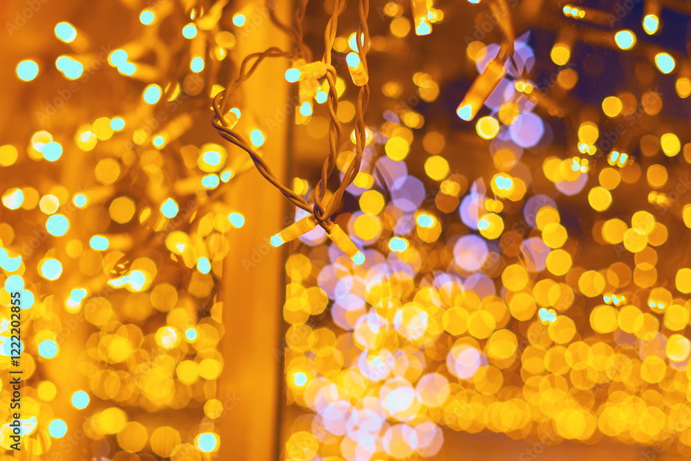 Christmas fairy lights, blurred to create a beautiful bokeh effect. Tangled lights hang in a warm and festive manner, capturing the essence of holiday decorations and their glowing ambiance
