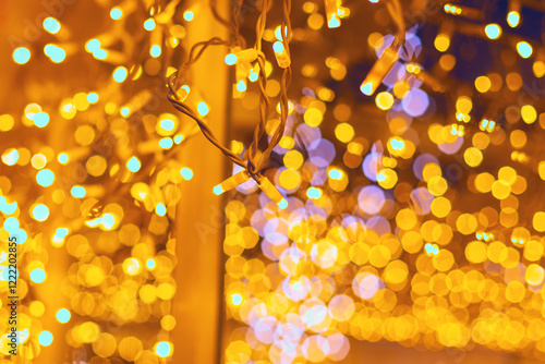 Obraz na płótnie Christmas fairy lights, blurred to create a beautiful bokeh effect. Tangled lights hang in a warm and festive manner, capturing the essence of holiday decorations and their glowing ambiance w salonie