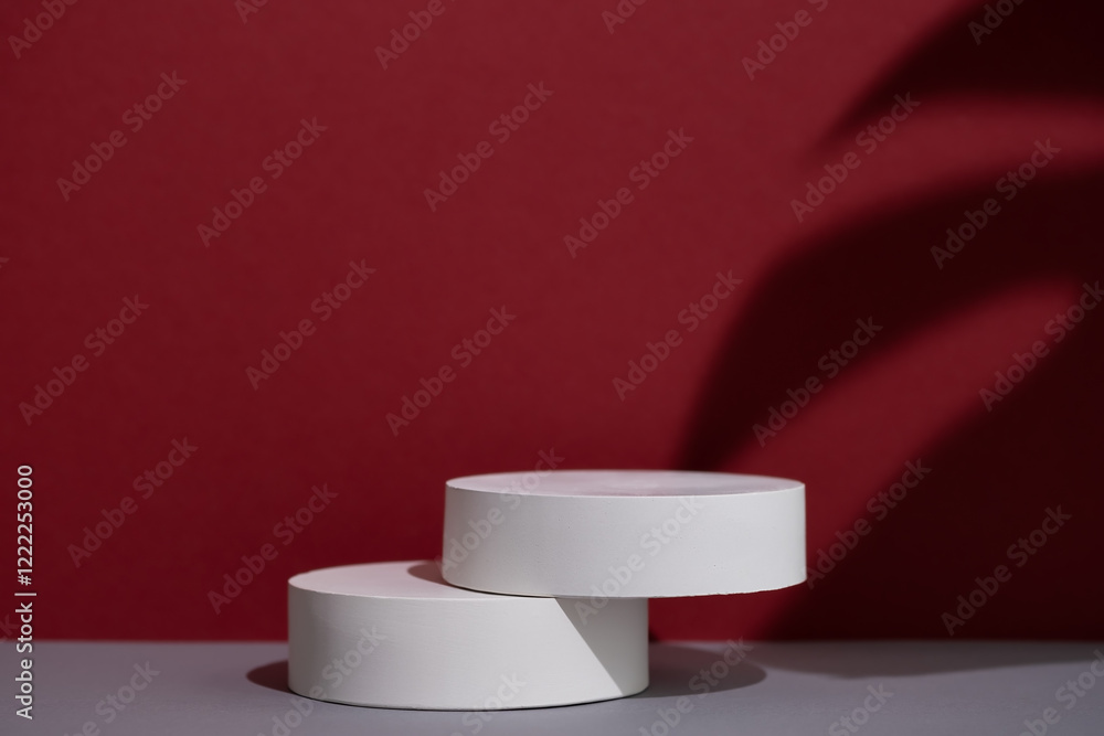 Geometric white scene with the shadow of a monstera leaf on a gray and burgundy background. A premium podium for advertising and presentation of your product. Showcase, display case. Geometric white scene with the shadow of a monstera leaf on a gray and burgundy background. A premium podium for advertising and presentation of your product. Showcase, display case.