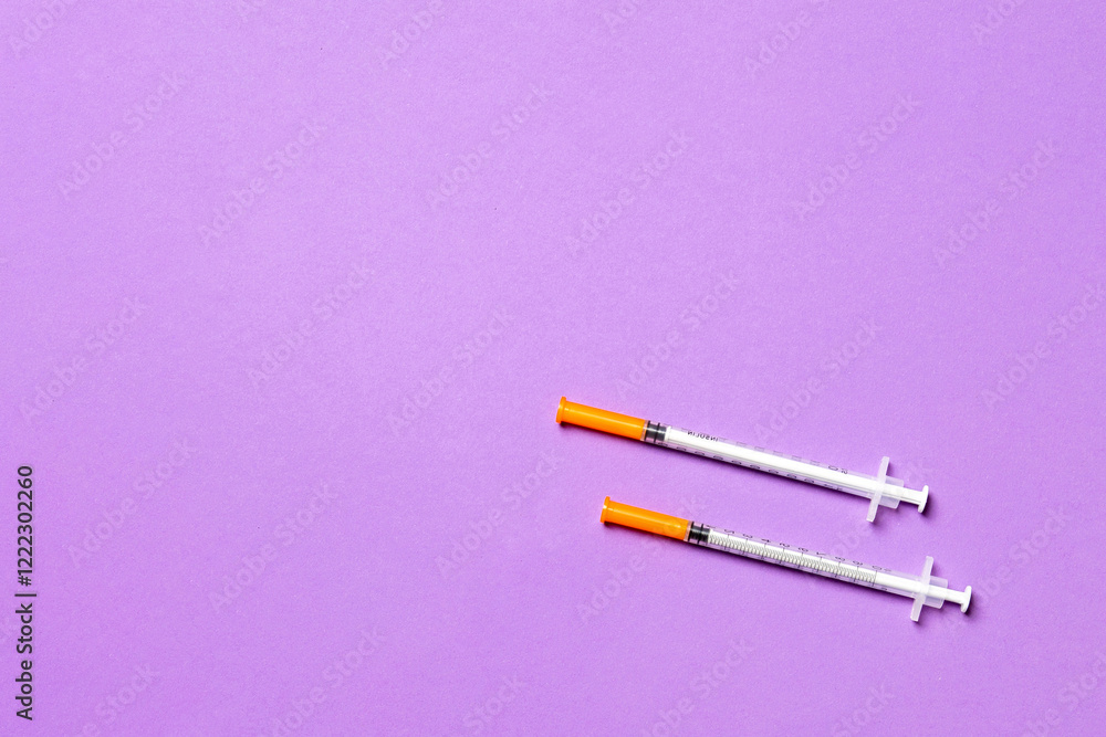 Top view of two insulin syringe at colorful background with copy space. High level of glucose concept Top view of two insulin syringe at colorful background with copy space. High level of glucose concept