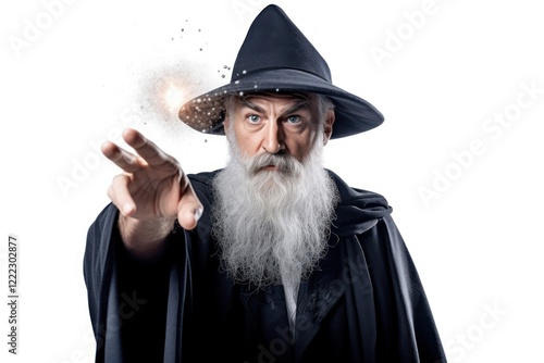 Grey-haired bearded wizard in a gray cassock and a cap is practicing sorcery portrait adult white background. photo