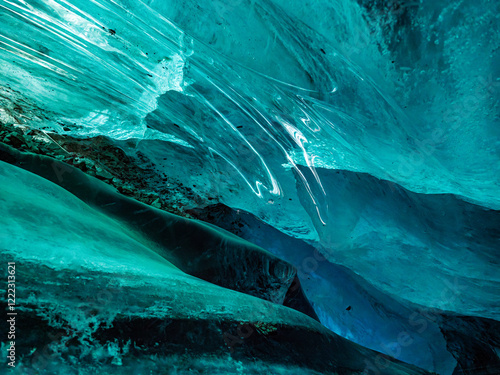 Inside a mountain glacier. Ice in a cave. Fantastic shape and incredible turquoise color. Bogdanovich Glacier photo