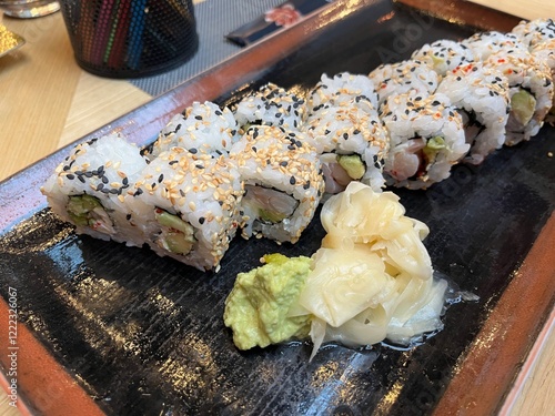 Close up sushi roll on black plate in Japanese restaurant