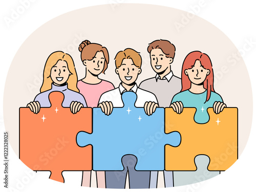 Friendly team of men and women hold giant puzzle pieces symbolizing working together to solve business problems. Business people with smile doing teamwork to increase company income