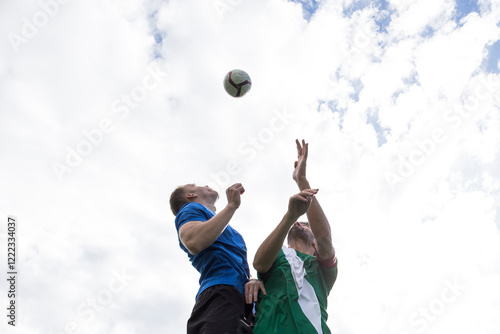 Football players jumping to head the ball during a football match photo