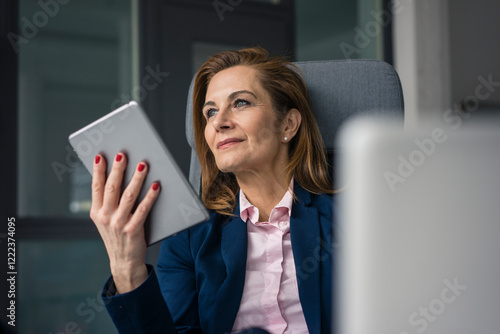 Confident busineswoman sitting in office, using digital tablet photo