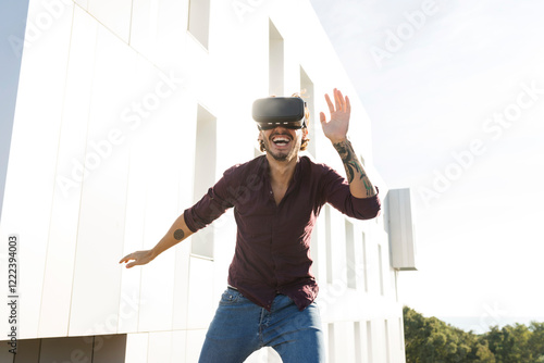 Man on a rooftop terrace, gaming with VR glasses photo