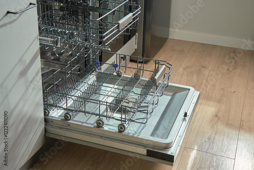 Obraz na płótnie Open empty dishwasher with empty racks and extended basket in modern kitchen ready for loading. Home appliance w salonie