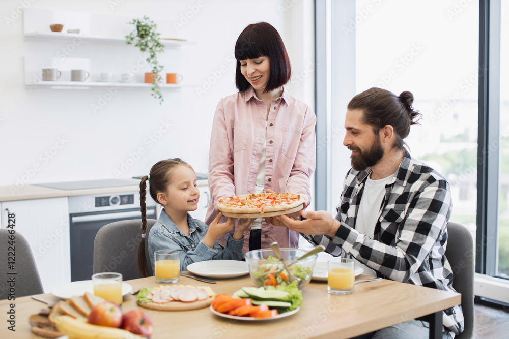 Caucasian family with young daughter enjoying pizza breakfast at home. Smiling parents and child sharing quality time in bright kitchen. Concept of family bonding and casual dining. Caucasian family with young daughter enjoying pizza breakfast at home. Smiling parents and child sharing quality time in bright kitchen. Concept of family bonding and casual dining.