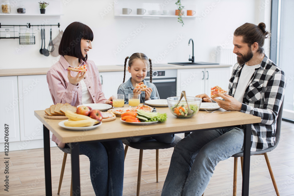 © sofiko14 - Caucasian family with young girl having breakfast with pizza. Parents and child sitting at table enjoying meal. Bright kitchen setting with fruits and vegetables. © sofiko14 - Caucasian family with young girl having breakfast with pizza. Parents and child sitting at table enjoying meal. Bright kitchen setting with fruits and vegetables.