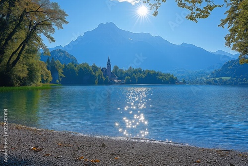 Sun shining over lake bled island with pilgrimage church of the assumption of maria on a beautiful summer day photo